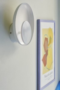 Lampa ścienna MARSI Nordlux 1xLED Metal Biały zamontowana na ścianie obok kolorowej grafiki.