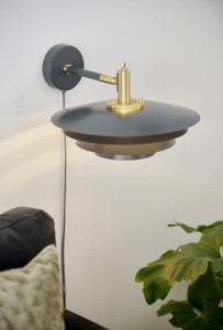 Lampa ścienna BRETAGNE Nordlux 1xG9 25W Metal Szary na tle ściany obok sofy i rośliny.