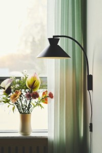 Lampa ścienna DIAL Nordlux 1xE27 40W Metal Czarny przy oknie.