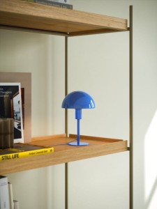 Lampa stołowa ELLEN Nordlux niebieska na drewnianej półce.