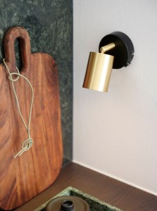Lampa ścienna EXPLORE Nordlux 1xGU10 35W Metal Mosiądz zamontowana na białej ścianie.