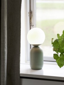 Lampa stołowa NOTTI Nordlux 1xE14 25W Metal Zielony na parapecie okna.