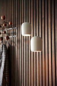 Lampa wisząca NOTTI Nordlux 1xE27 25W Metal Szary na tle drewnianej ściany.