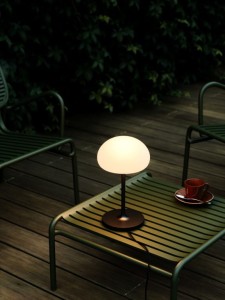 Lampa na baterie SPONGE Nordlux 1xLED Czarny na stoliku ogrodowym.