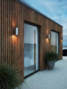 Lampa ścienna TIN Nordlux 2xGU10 25W Stal galwanizowana Ocynkowany zamontowana na drewnianej elewacji nowoczesnego domu.