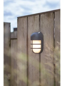 Kinkiet zewnętrzny LED Lutec Bullo 6383001118 IP54 zamontowany na drewnianym płocie.
