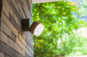 Kinkiet zewnętrzny LED Lutec Dropsi 5010901118 na ceglanej ścianie.