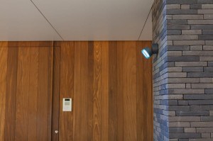 Kinkiet zewnętrzny LED Lutec Dropsi 5010901118 na ścianie z cegieł aluminiowy szary.