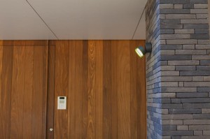 Kinkiet zewnętrzny LED Lutec Dropsi 5010901118 na ścianie z cegły.