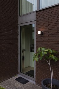 Kinkiet zewnętrzny LED Lutec Cuba 5193803012 IP54 1xLED Aluminium Czarny na ścianie przy drzwiach.