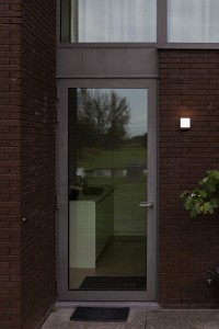 Kinkiet zewnętrzny LED Lutec Cuba 5193803012 zamontowany obok drzwi wejściowych.