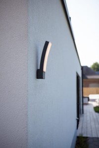 Kinkiet zewnętrzny LED Lutec Kira 5288902118 zamontowany na ścianie domu.