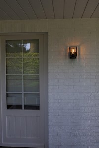 Lampa elewacyjna Lutec Shiva 5206501012 IP44 zamontowana na zewnętrznej ścianie domu.