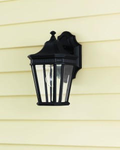 Kinkiet zewnętrzny Elstead Lighting Cotswold Lane FE-COTSLN2-S-BK IP44 1xE27 Aluminium Czarny na żółtej elewacji.