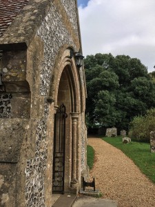 Kinkiet zewnętrzny Elstead Lighting Parish PR2-BLACK zamontowany przy kamiennej ścianie.