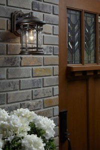 Kinkiet zewnętrzny Elstead Lighting Marblehead QZ-MARBLEHEAD2-M na ścianie obok drzwi.