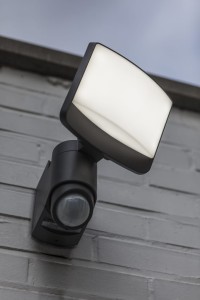 Naświetlacz LED Lutec Sunshine Solar z czujnikiem ruchu zamontowany na ścianie.