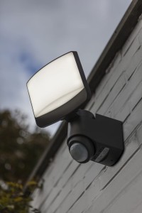 Naświetlacz LED Lutec Sunshine z czujnikiem ruchu zamontowany na ścianie.