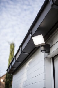 Naświetlacz LED Lutec Sunshine z czujnikiem ruchu zamontowany na elewacji budynku.