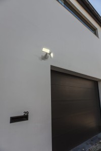 Naświetlacz LED Lutec Arc z czujnikiem ruchu zamontowany nad garażem.