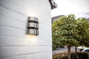 Kinkiet zewnętrzny LED Lutec Maya 5198401001 zamontowany na białej ścianie.