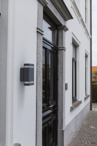 Kinkiet zewnętrzny LED Lutec Focus 5605013118 zamontowany przy drzwiach wejściowych.