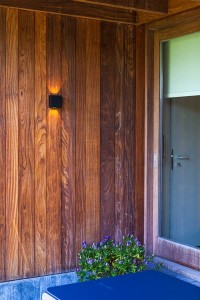 Kinkiet zewnętrzny LED Lutec Gemini 5104003012 IP54 czarny na drewnianej elewacji.