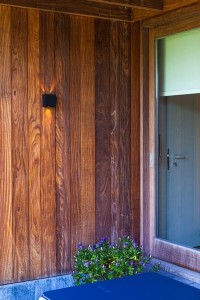 Kinkiet zewnętrzny LED Lutec Gemini 5104003012 na drewnianej elewacji.