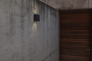 Kinkiet zewnętrzny LED Lutec Gemini 5104003012 zamontowany na betonowej ścianie