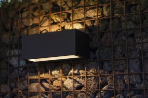 Kinkiet zewnętrzny LED Lutec Gemini 5189112012 czarny montowany na kamiennej ścianie.