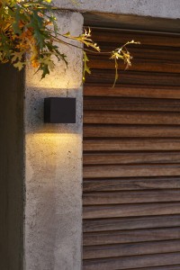 Kinkiet zewnętrzny LED Lutec Gemini 5189125012 oświetlający ścianę przy garażu.