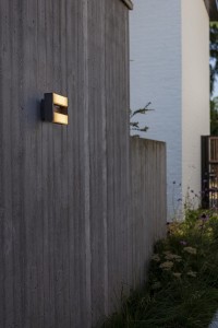 Kinkiet zewnętrzny LED Lutec Conroy 5107001118 zamontowany na betonowej ścianie.