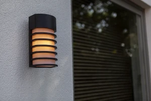 Nowoczesny kinkiet zewnętrzny Lutec Fulton 5207601012 zamontowany na ścianie.