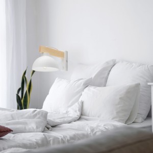 Kinkiet OSLO TK Lighting 1xE27 15W Metal Biały zamontowany na ścianie w sypialni.