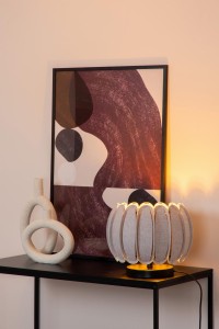Lampa stojąca Spencer Lucide 1xE27 40W na czarnym stoliku obok ozdobnej rzeźby i abstrakcyjnego obrazu.