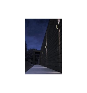 Lampa Ścienna Nordlux LED Mosiądz oświetlająca zewnętrzną ścianę domu nocą.