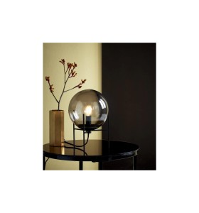 Lampa Stołowa Nordlux E14 15W Czarny na czarnym stoliku obok złotego wazonu