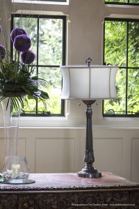 Lampa stojąca Presidential Elstead Lighting 2x60W E27 Metal Srebrny na ozdobnym stole przy oknie.