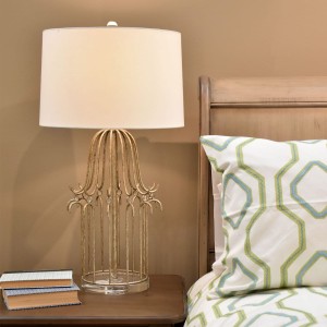 Lampa stojąca Stella Elstead Lighting przy łóżku.