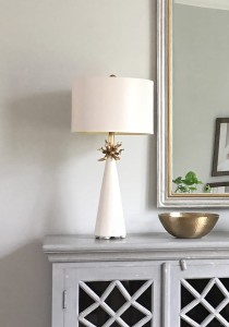 Lampa stojąca Neo Elstead Lighting na komodzie obok złotej miski.