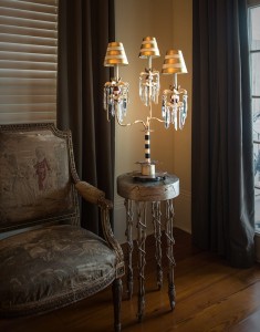 Lampa stojąca Birdland Elstead Lighting 1x60W E27 Stal Wielokolorowy na rustykalnym stoliku w eleganckim wnętrzu.