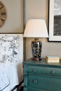 Lampa stojąca Black Birds Elstead Lighting na stoliku nocnym przy łóżku.