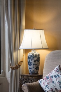Lampa stojąca Blue Ginger Jar Elstead Lighting na drewnianym stoliku w salonie.