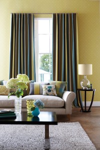 Lampa stojąca Orb Elstead Lighting w kolorze beżowym obok sofy w salonie.