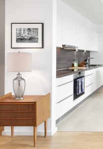 Lampa stojąca Nicolls Elstead Lighting na drewnianym stoliku w nowoczesnej kuchni.