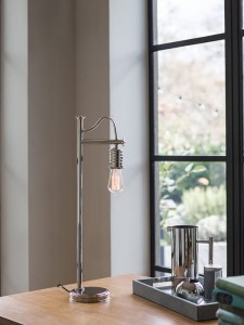 Lampa stojąca Douille Elstead Lighting 1x60W E27 Stal Chrom na drewnianym stole przy oknie.