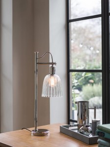 Lampa stojąca Douille Elstead Lighting na drewnianym biurku przy oknie.