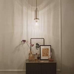 Lampa wisząca Kimrose Elstead Lighting z polerowanego niklu nad komodą.