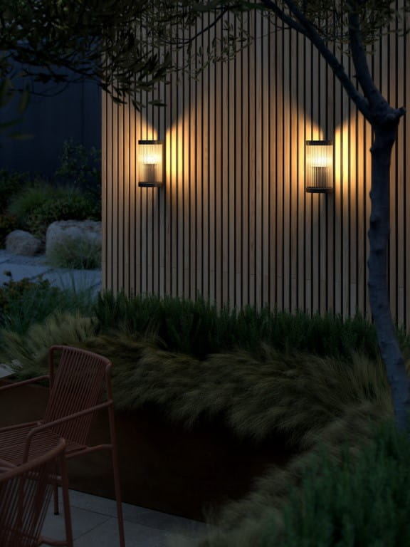 Lampa ścienna COUPAR Nordlux oświetlająca ogród.