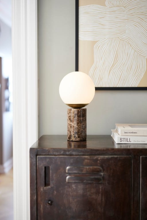 Lampa stołowa LILLY Nordlux 1xE14 25W Szkło Brązowy stojąca na szafce w eleganckim wnętrzu.